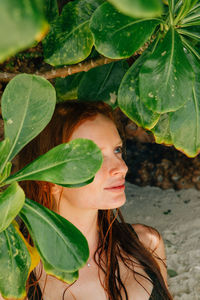 Close-up of young woman amidst leaves