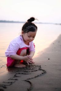 Happy girl on beach against sky