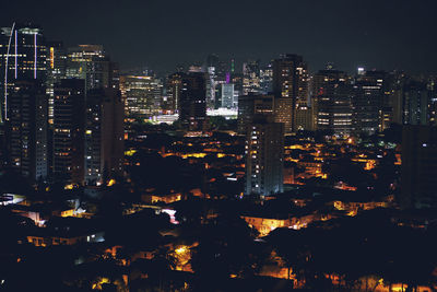 Illuminated cityscape against sky at night