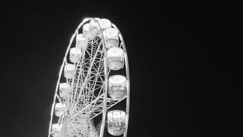 Low angle view of illuminated ferris wheel against sky at night