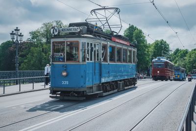 Train at railroad station in city against sky