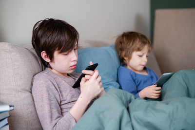 People texting. two boys chatting in bed before sleeping