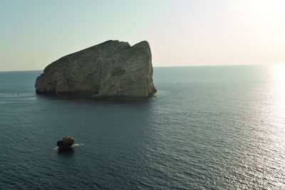 Scenic view of rocks in sea against clear sky