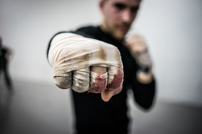 Midsection of man punching with injured hand