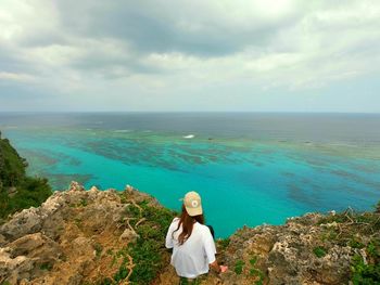 Woman looking at sea against sky