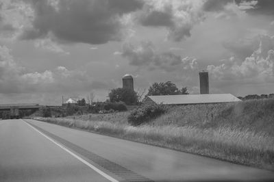 Road by trees against sky