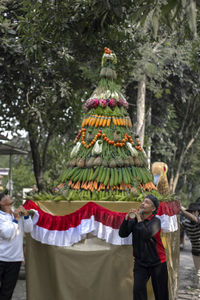 Rear view of people standing by tree