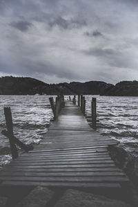 Wooden pier over sea against sky