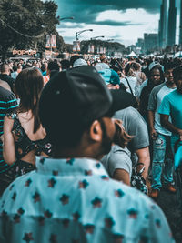 Rear view of people walking on street in city