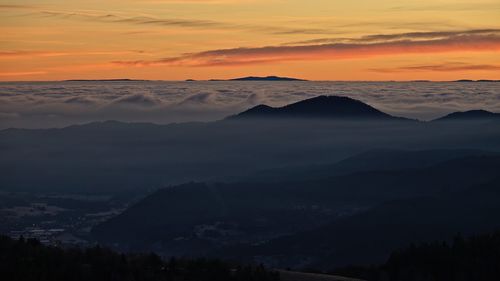 Scenic view of silhouette mountains against romantic sky at sunset