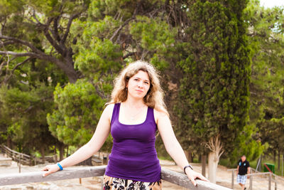 Portrait of smiling woman against trees