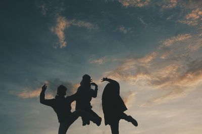 Low angle view of silhouette man standing against sky during sunset