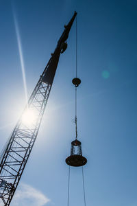 Low angle view of crane against sky