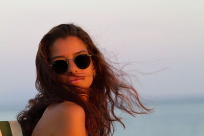 Close-up of young woman against clear sky