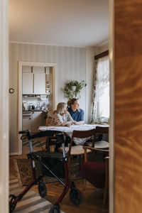 Senior woman sitting with female caregiver at home