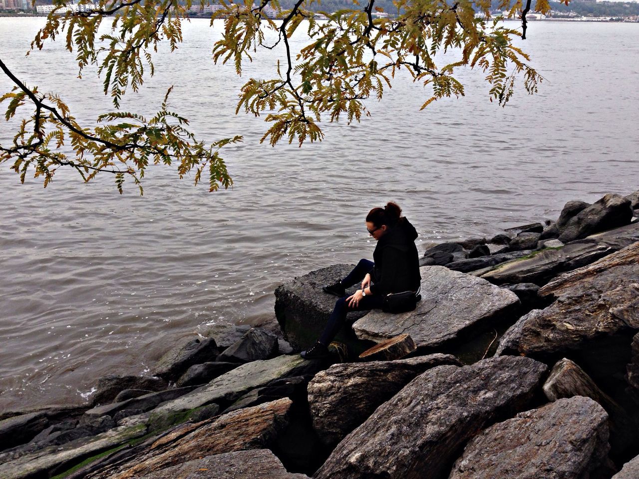 water, lifestyles, leisure activity, full length, rock - object, casual clothing, nature, standing, tree, men, sitting, rear view, sea, river, tranquility, high angle view, lake, beauty in nature