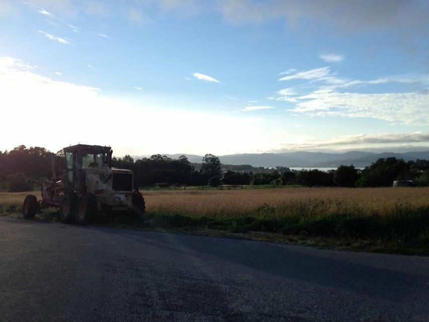 sky, transportation, field, landscape, road, tree, rural scene, cloud - sky, grass, cloud, land vehicle, tranquility, tranquil scene, agriculture, country road, the way forward, nature, scenics, street, farm