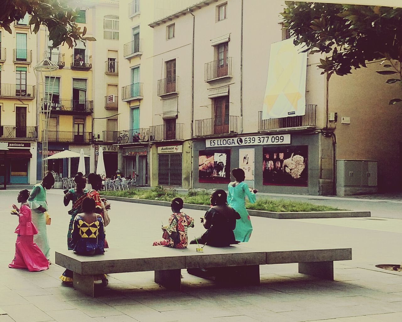 architecture, building exterior, built structure, group of people, real people, city, women, men, building, sitting, nature, day, plant, people, tree, outdoors, adult, group, residential district, medium group of people