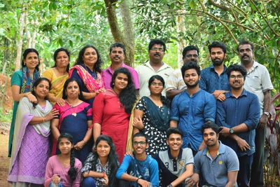 Portrait of family standing against trees