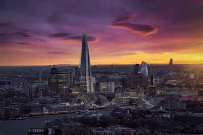 Illuminated cityscape against sky during sunset