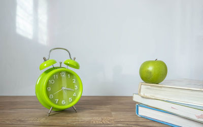 Green apples on table against wall