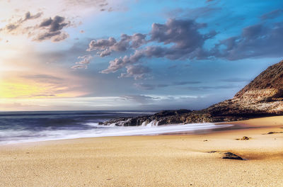 Scenic view of beach against sky during sunset