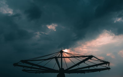 Low angle view of silhouette rollercoaster against sky