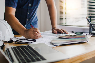 Midsection of man using laptop on table