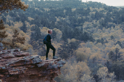 Side view of a man standing on rock