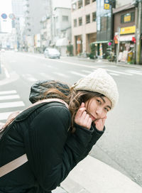 Portrait of smiling young woman on street in city