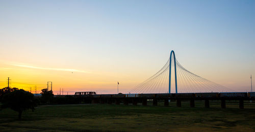 Suspension bridge against sky during sunset