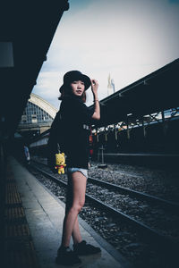 Woman standing on railroad station platform