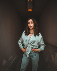 Portrait of woman standing against wall