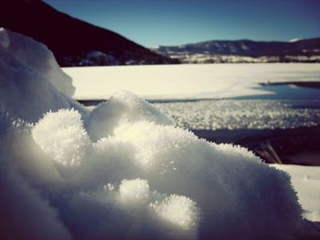 Close-up of snow on sea against sky