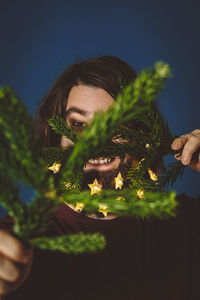 Close-up of woman against plants at night
