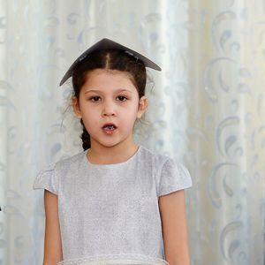 Portrait of cute girl standing against wall