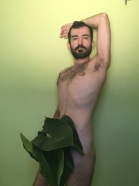 Portrait of young man standing against wall