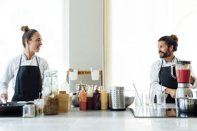 Young man and woman standing at home