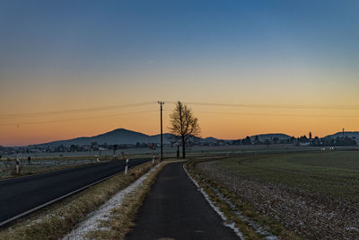 Road against clear sky during sunset