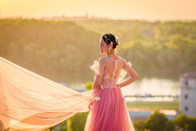 Woman with umbrella standing against blurred background