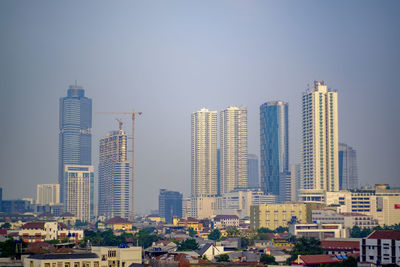 Modern buildings in city against clear sky