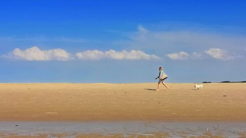 Woman walking with dog at beach