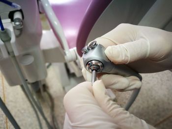 Close-up of hand wearing gloves while holding machine