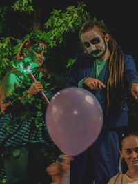 Portrait of a young man holding balloons