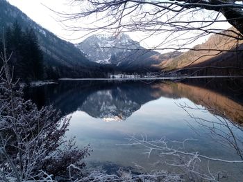 Scenic view of lake by snowcapped mountains against sky