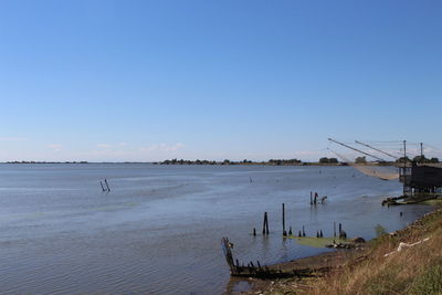 Boats in sea against clear sky