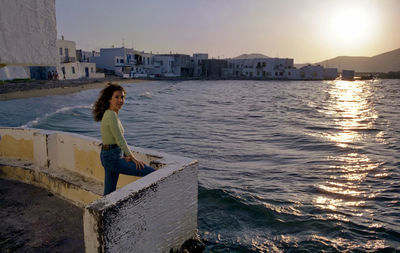 Portrait of woman standing by sea against sky