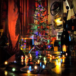 Close-up of illuminated bottles on table at night