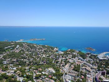 High angle view of town by sea against clear sky