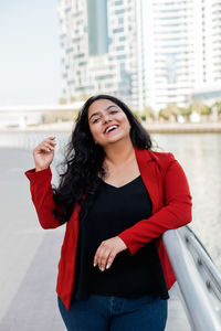 Portrait of a young and elegant indian asian woman standing on the embankment in the afternoon.